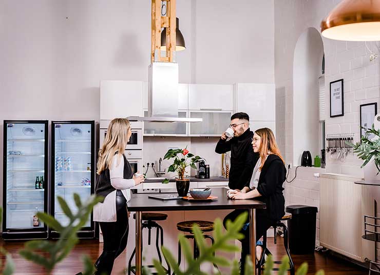 3 Personen stehen zusammen in der Küche des Coworking Lofts Kreuzau.